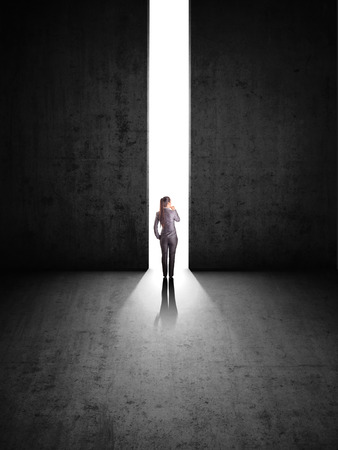 businesswoman against black wall with holeの写真素材