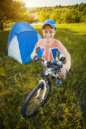 Kid with a tent on a camomile meadowの写真素材