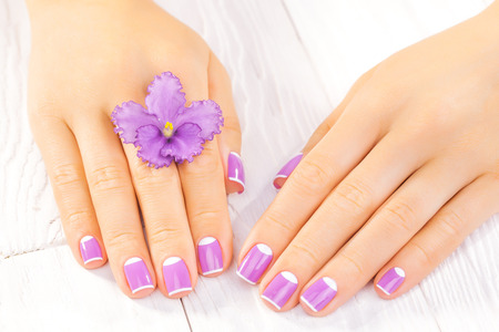 beautiful french manicure with purple violet flowersの写真素材