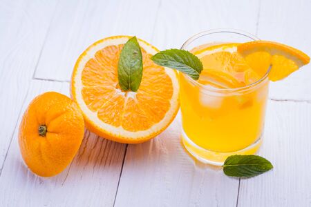 orange alcohol cocktail on a white wooden table.の写真素材