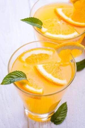 orange alcohol cocktail on a white wooden table.の写真素材