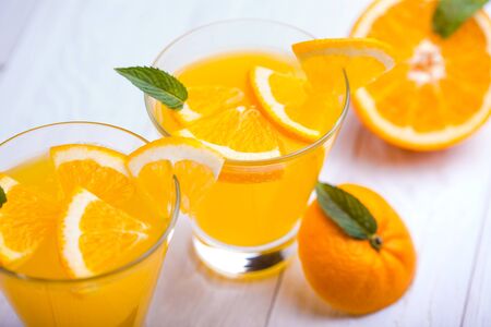 orange alcohol cocktail on a white wooden table.の写真素材