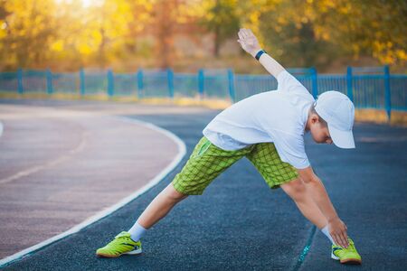 Boy Teen doing sports exercises on a stadium. outdoorの写真素材