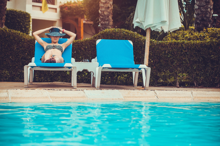 beautiful woman lying on a lounger by the poolの写真素材