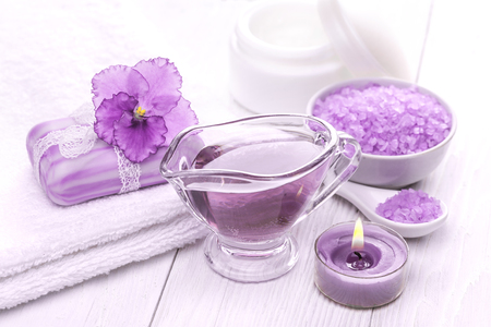 Spa still life of sea salt and essential oils and purple violet flowerの写真素材