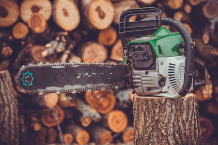 Close-up professional chainsaw blade cutting log of woodの写真素材