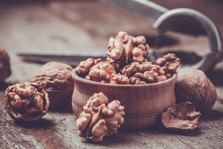 Walnut kernels and whole walnuts on old wooden table