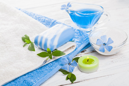 Spa still life of sea salt and essential oils and periwinkle flowersの写真素材