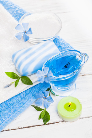 Spa still life of sea salt and essential oils and periwinkle flowersの写真素材