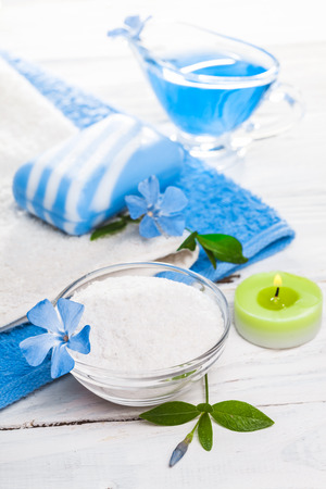Spa still life of sea salt and essential oils and periwinkle flowersの写真素材