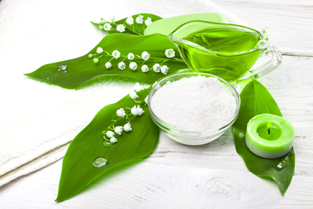 Spa still life of sea salt and essential oils and lily of the valley flowersの写真素材