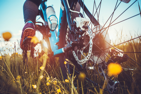 low angle view of cyclist riding mountain bike on the meadowの写真素材