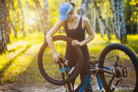 woman repair her bicycle in the forestの写真素材