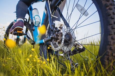 low angle view of cyclist riding mountain bike on the meadowの写真素材