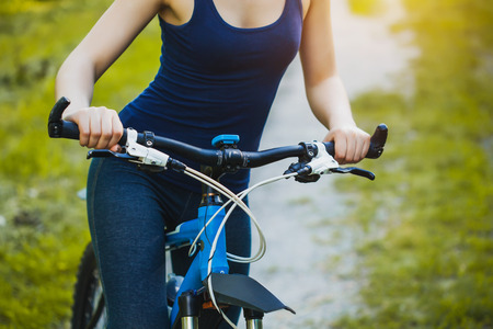 Woman mountain biking and holding handlebars in the natureの写真素材