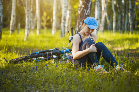 girl fell from the bike in a summer parkの写真素材