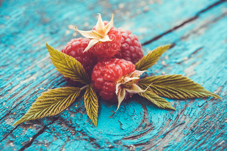 Fresh raspberry on a blue ancient wooden tableの写真素材