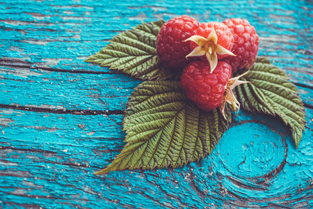 Fresh raspberry on a blue ancient wooden table