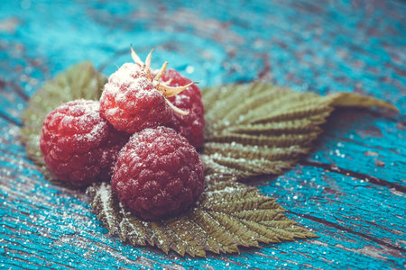 Fresh raspberry on a blue ancient wooden table