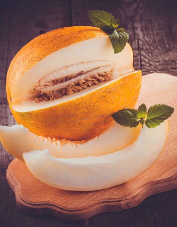Fresh sweet orange melon on the wooden table, selective focus and toned imageの写真素材