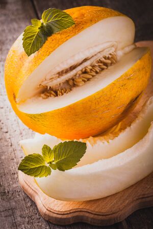 Fresh sweet orange melon on the wooden table, selective focus and toned imageの写真素材