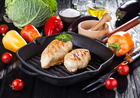 Tasty Grilled chicken fillet and bell pepper on a pap on the black wooden table.の写真素材