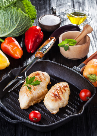 Tasty Grilled chicken fillet and bell pepper on a pap on the black wooden table.の写真素材