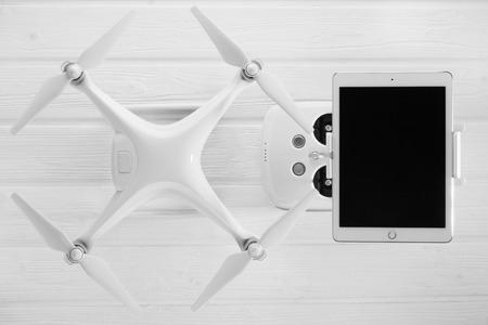 concept quadrocopter, tablet and remote control on a white wooden backgroundの写真素材