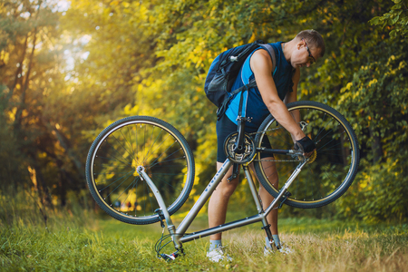 man repair his bicycle in the forestの写真素材