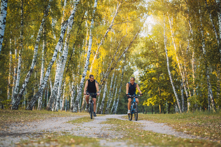 Two mountain bikers riding bike in the summer forestの写真素材
