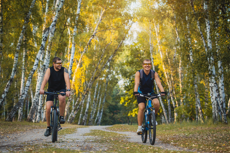Two mountain bikers riding bike in the summer forestの写真素材