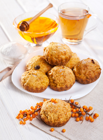 muffins with tea, sea-buckthorn berries and honey on the white wooden backgroundの写真素材