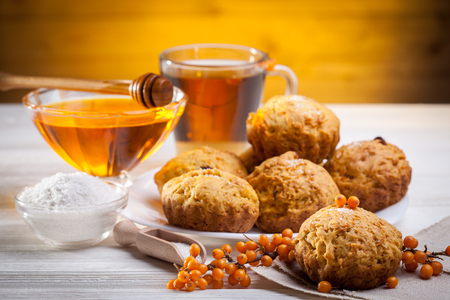 muffins with tea and honey on the white wooden backgroundの写真素材