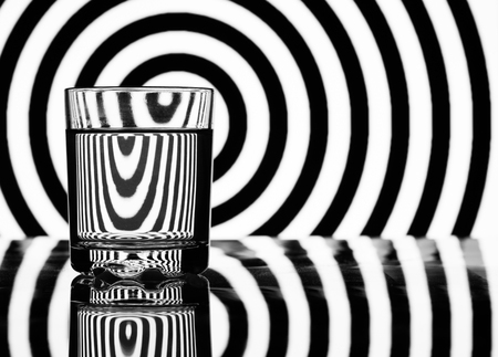 glass of water on a background of black and white geometric shapesの写真素材