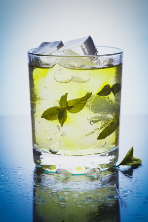 Mojito cocktail with mint and ice in glass on the blue backgroundの写真素材