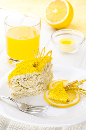 homemade yellow lemon cake with cream protein with the decor on a white wooden tableの写真素材