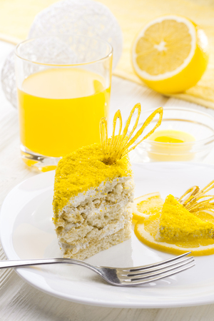 homemade yellow lemon cake with cream protein with the decor on a white wooden tableの写真素材