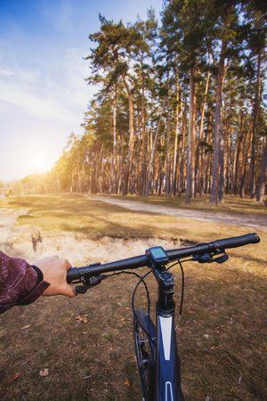 man cyclist rides in the forest on a bike. first-person viewの写真素材