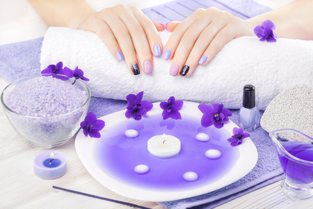 beautiful blue manicure with violet, candle and towel on the white wooden table. spaの写真素材
