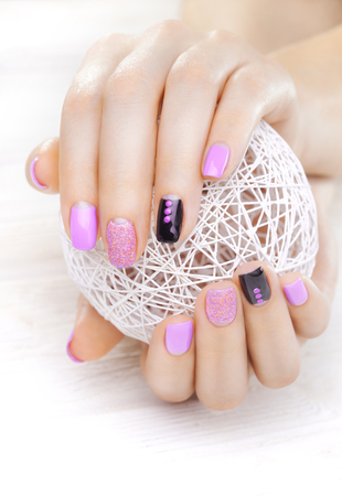 purple manicure with a white ball of yarn on the white wooden table.の写真素材