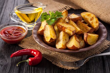 Closeup of fried rosemary potato wedges in a rustic setting.の写真素材