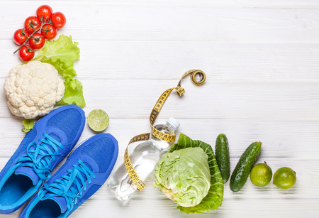 Fitness, active lifestyles Concept. Fresh healthy vegetables, sport shoes on white wood background. copy space for text. Top viewの写真素材