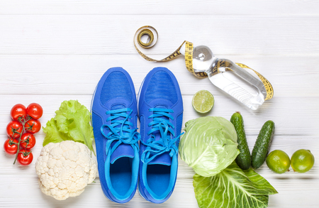 Fitness, active lifestyles Concept. Fresh healthy vegetables, sport shoes on white wood background. copy space for text. Top viewの写真素材