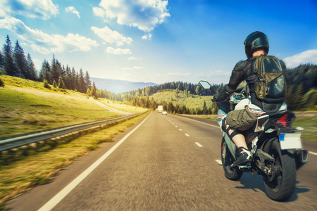 Motorcyclist rushes along the picturesque mountain highwayの写真素材