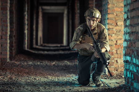 airsoft soldier with a rifle playing strikeball In brick buildingの写真素材