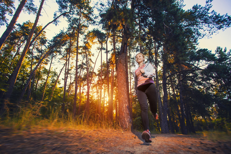 nice young girl on morning jog in a summer forestの写真素材
