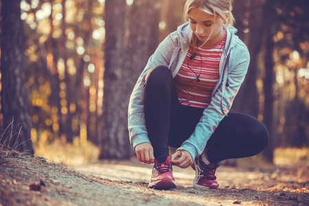 woman Runner tying shoelaces on sneakers.の写真素材