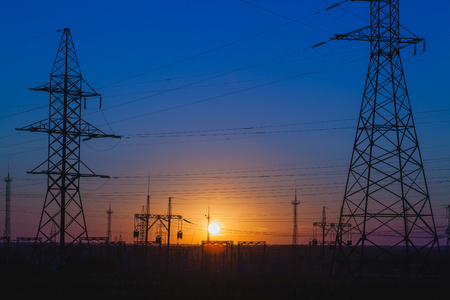 high-voltage power lines at sunset.の写真素材