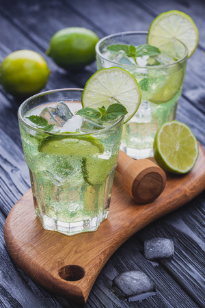 refreshing cold mojito with ice on a black wooden tableの写真素材