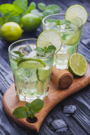 refreshing cold mojito with ice on a black wooden tableの写真素材